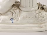 a figurine of a woman laying on top of a pillar