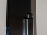 a black refrigerator with a blue handle in a kitchen