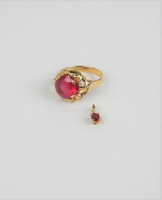 gros plan d'une bague en or avec une pierre en rubis