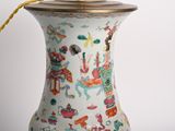 a white vase with a gold handle on a table