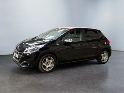 the black car is parked in a room with a white wall
