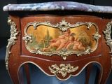 a small wooden table with a painting on it