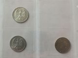 three different coins in a clear plastic case on a white surface