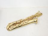 un saxophone doré posé sur une surface blanche