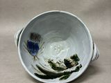 a white bowl with blue flowers in it on a table