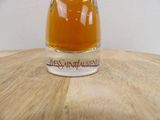 a small glass jar of honey sitting on a wooden table