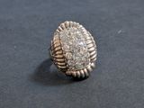an image of a silver ring with diamonds on a black surface