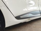 a close up of a white car with a denting on it