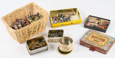 de nombreuses boîtes de jouets en fer blanc de toutes sortes dans un panier en osier