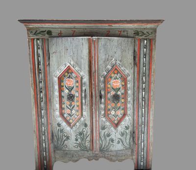 a wooden cabinet with two doors and a flower design on the door