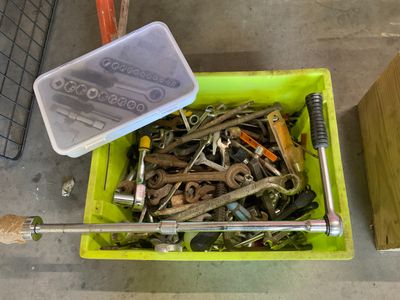 a green container filled with lots of screws and wrenches