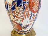 a vase that is sitting on a stand on a white surface