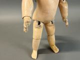 a wooden mannequin that is standing on a gray surface