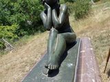 une statue représentant une femme assise sur un banc
