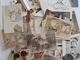 de nombreuses cartes postales anciennes posées sur une table recouverte d'une nappe rouge