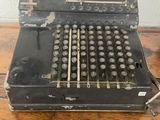 une vieille machine à écrire noire posée sur une table en bois