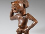une statue en bois d'un homme avec un chapeau sur la tête