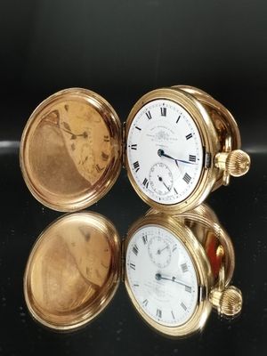 une montre de poche en or posée sur une table noire