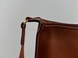 a close up of a brown leather purse with a brown strap