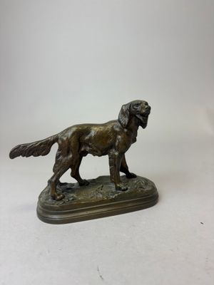 statue en bronze représentant un chien debout sur un socle, sur fond blanc