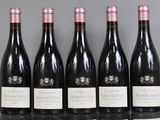 six bottles of wine are lined up in a row on a table