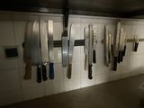many knives hanging on the wall in the kitchen