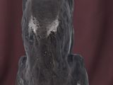 statue of a black cat sitting on a black base on a red background