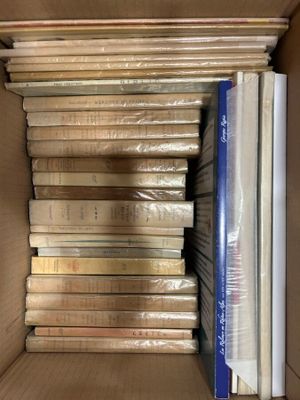 many books in a cardboard box on a shelf