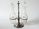 three glass vases on a metal stand with a candle holder