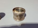 a silver ring sitting on top of a table next to a spoon