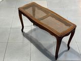 une table en bois avec un plateau en verre, posée sur un sol carrelé