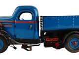 un camion jouet posé sur une surface blanche