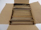 une boîte en carton remplie de vieux disques posée sur une surface blanche