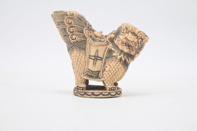 chinese carved ivory figurine of a winged lion with a shield