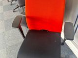 orange and black office chairs in a row in an empty room