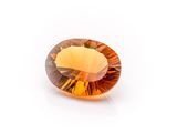a close up of a yellow sapphire stone on a white surface