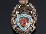 a badge on a black surface with a red heart on it