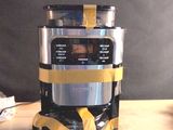 une cafetière argentée et noire posée sur une table en bois