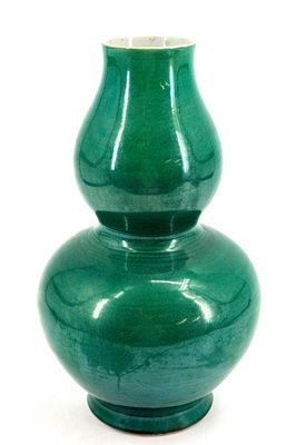 a green vase that is sitting on a white surface