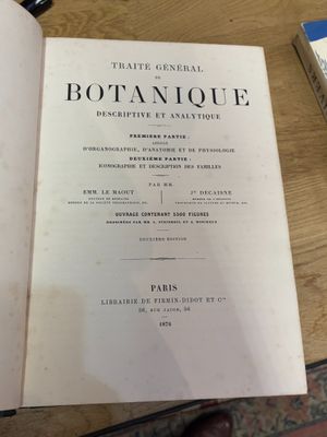 un livre ouvert posé sur une table en bois, à côté d'une tasse de café