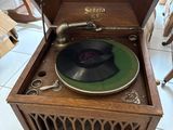 a record player sitting in a wooden box on a tile floor