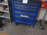 un garage avec un coffre à outils bleu et une boîte à outils rouge