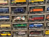many different types of toy trucks in a display case