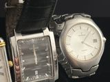 two watches sitting next to each other on a black surface