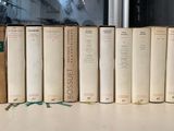 Plusieurs vieux livres sont alignés sur une étagère devant une fenêtre