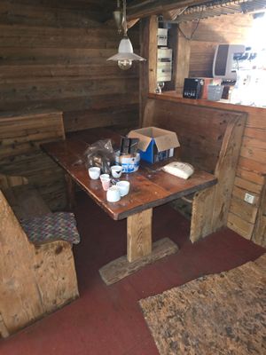 une table et des chaises dans une petite pièce aux murs en bois