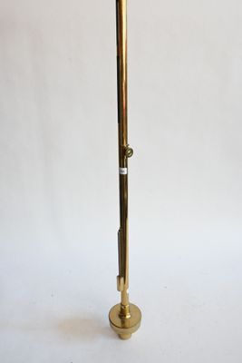 un grand mât en laiton surmonté d'une horloge