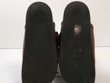 the back of a pair of black shoes with a brown heel