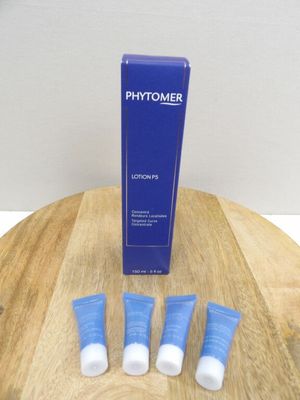 three tubes of phytomer sitting on a wooden table next to a tube of phytomer