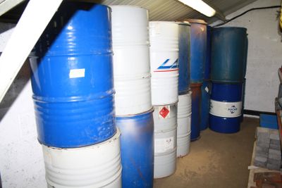 several blue and white barrels are stacked next to each other in a room